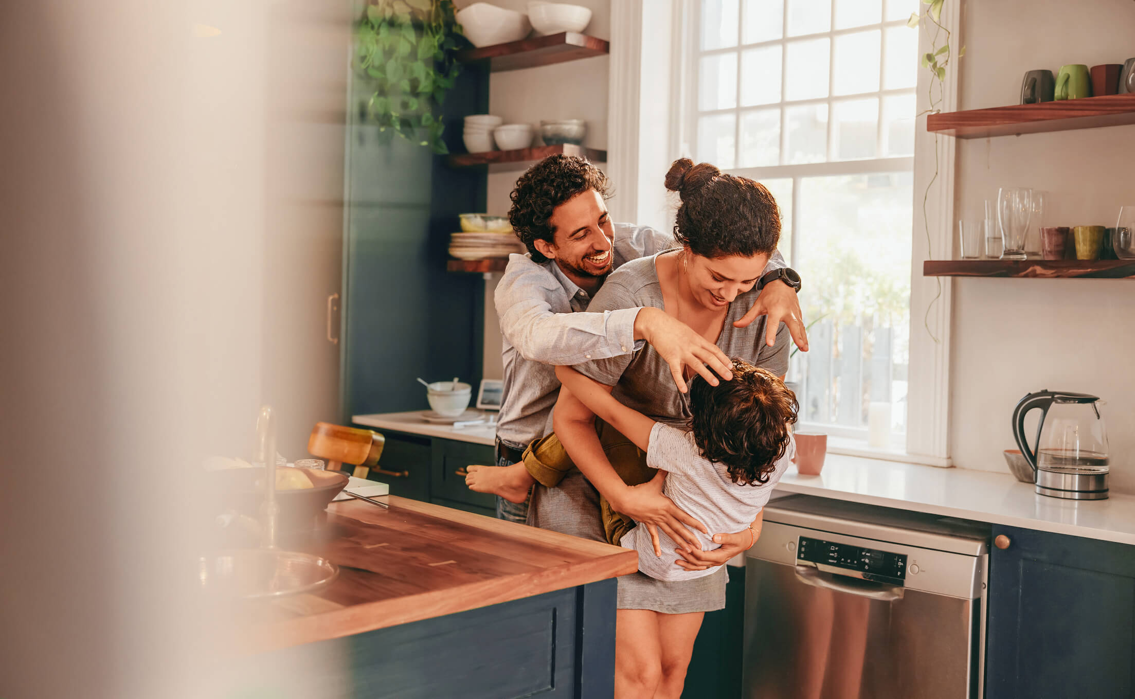 Parents playing with their child in the kitchen