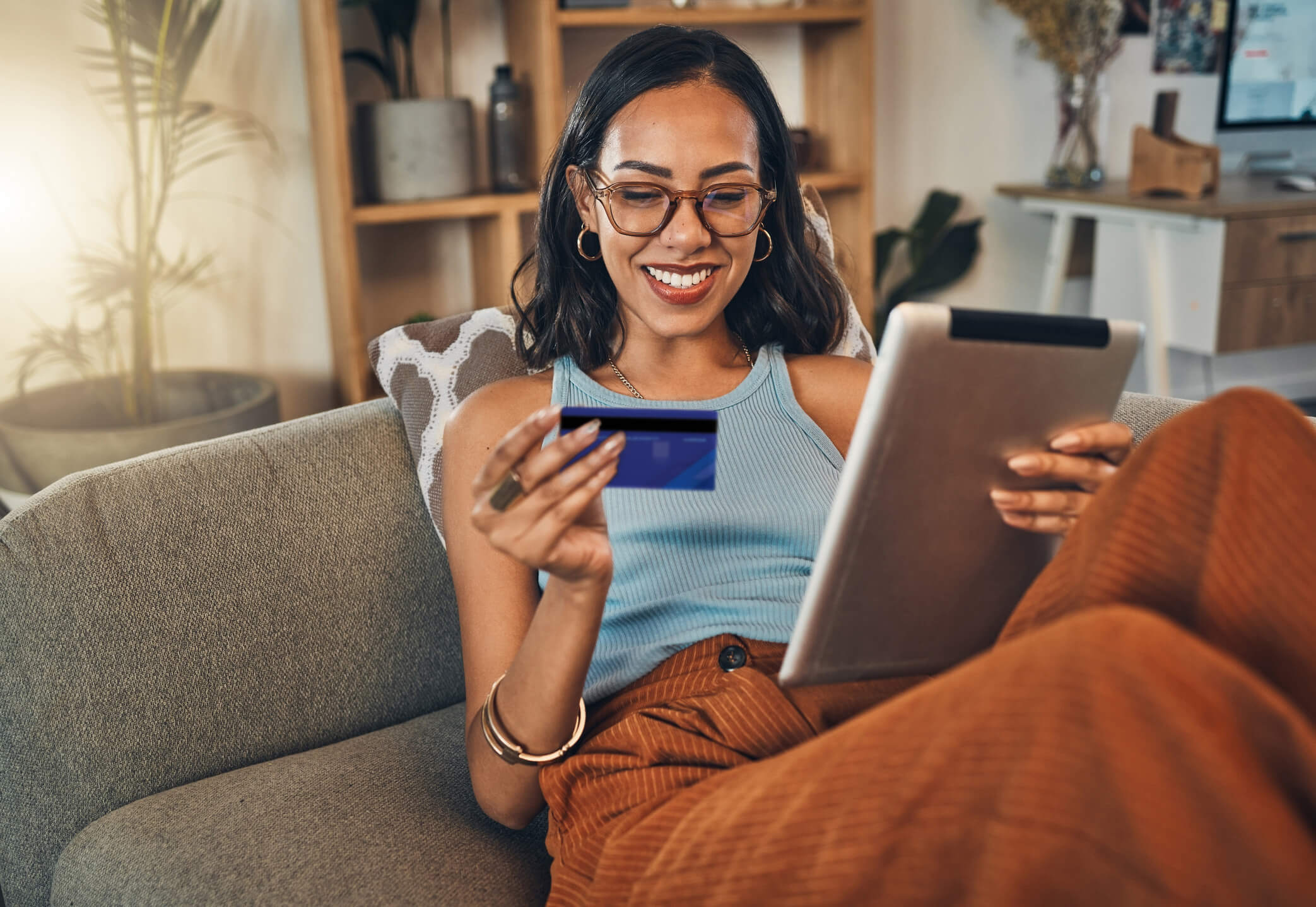 Person holding credit card and tablet