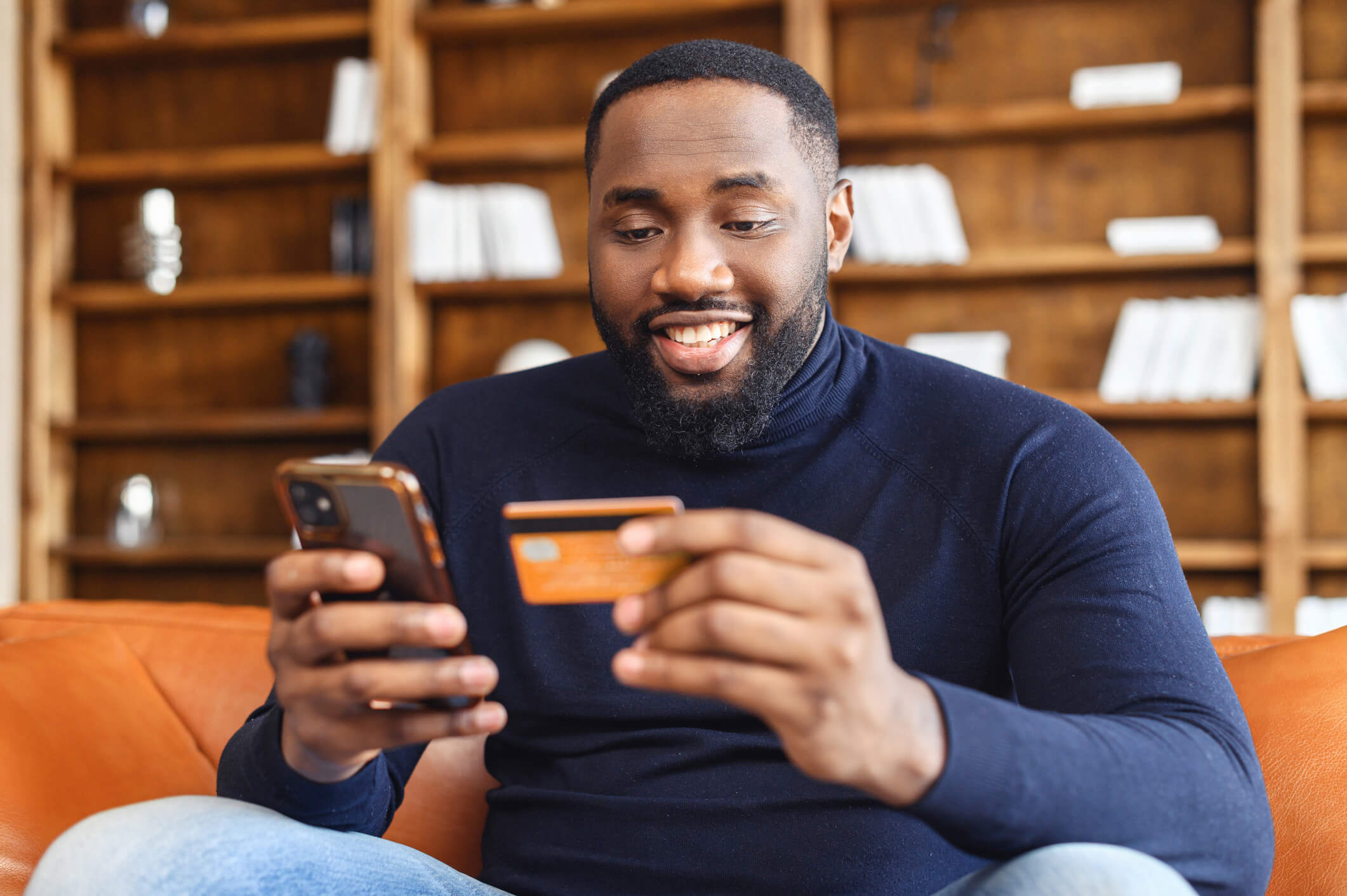 Person holding credit card and mobile phone